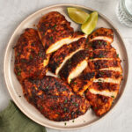 blackened chicken sliced on platter with green napkin