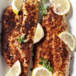 pan fried walleye served with lemon slices.