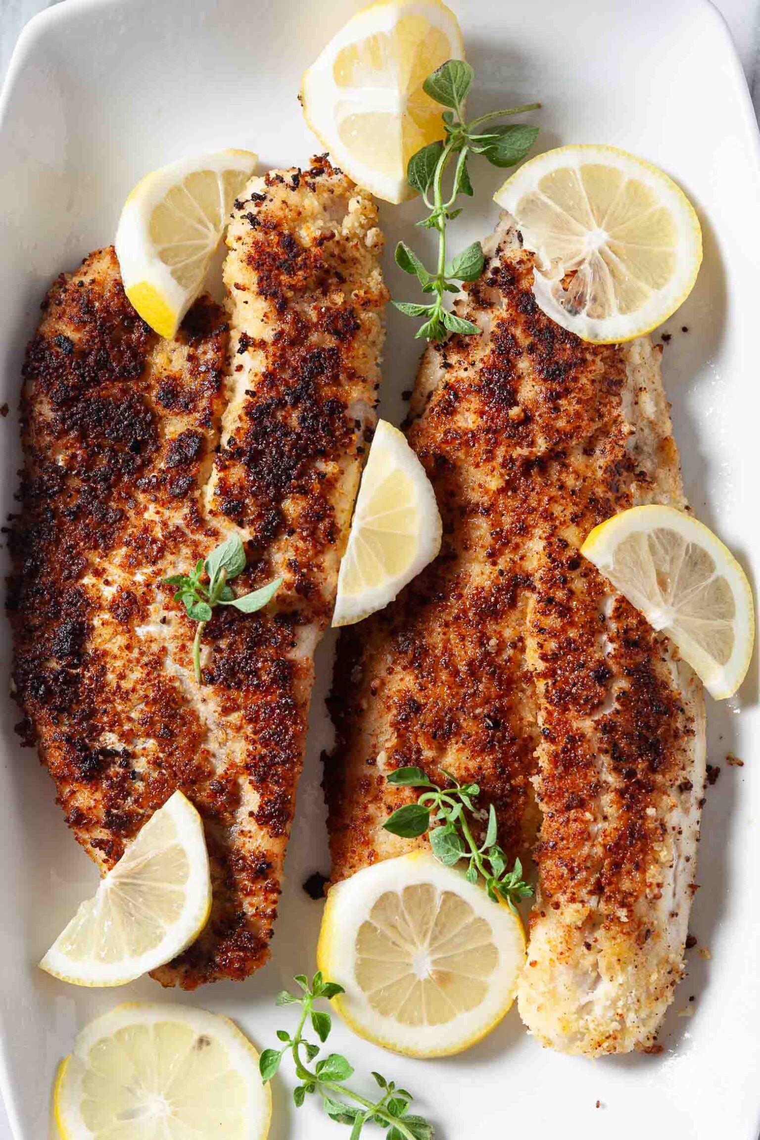 pan fried walleye served with lemon slices.