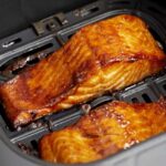 close up of air fryer salmon filets in an air fryer basket.