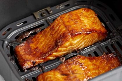 close up of air fryer salmon filets in an air fryer basket.