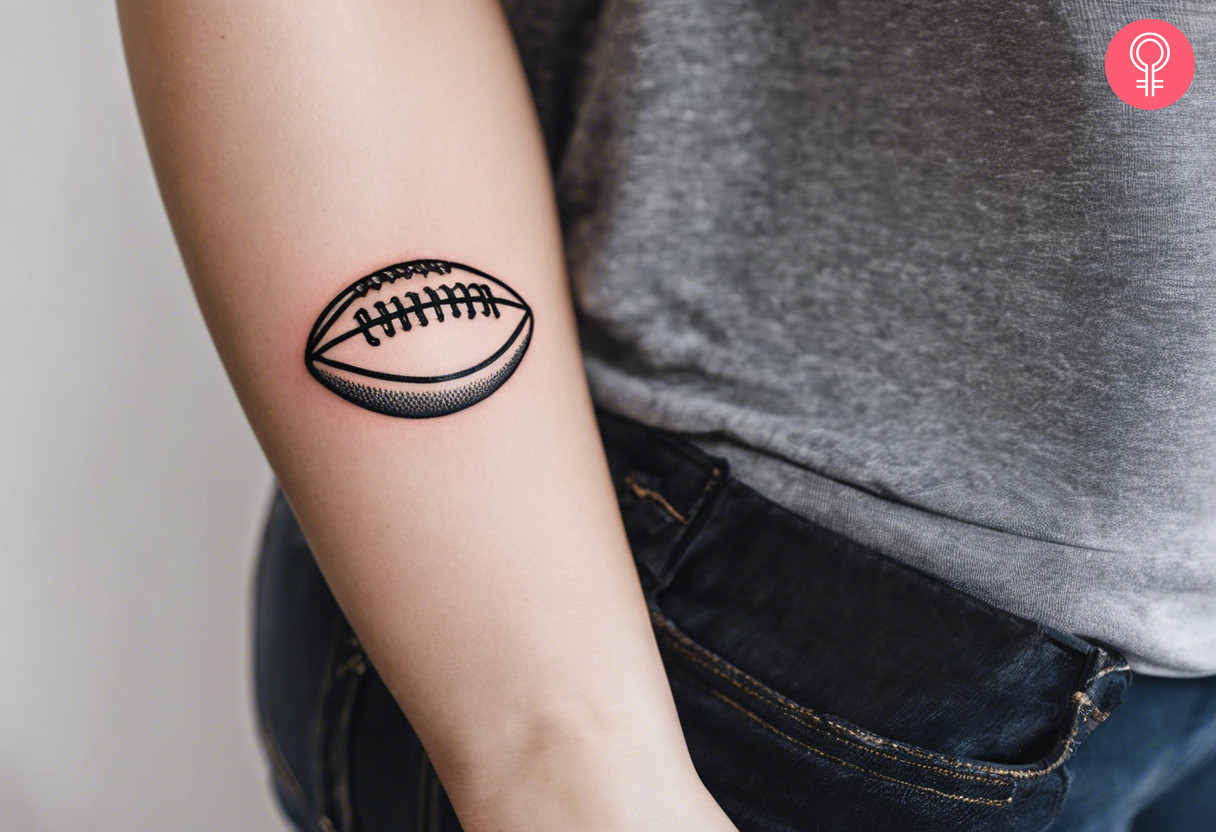 American-Football-Ball-Tattoo auf dem Unterarm einer Frau