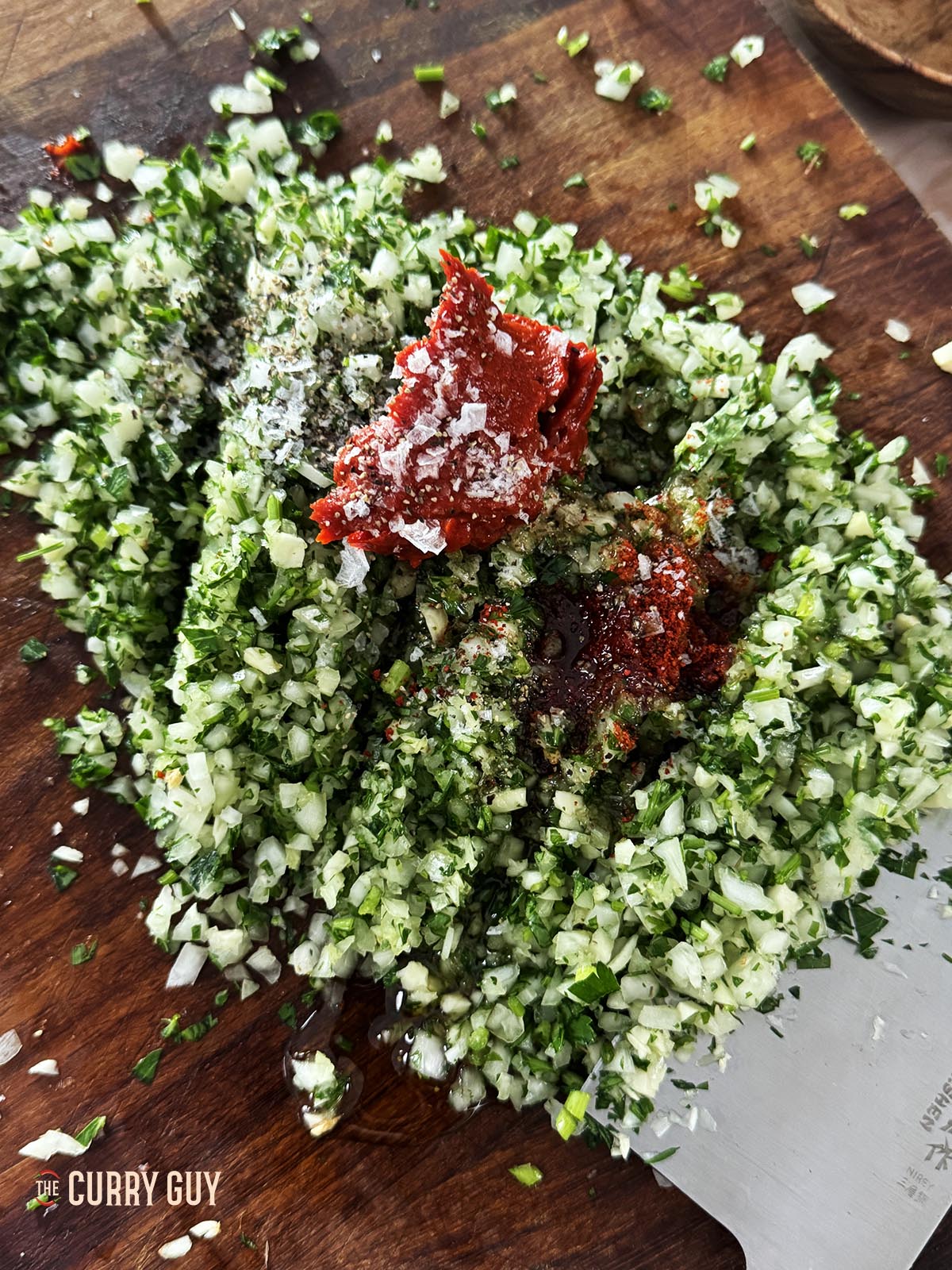 Frische Kräuter, Salz, Olivenöl, Zitronensaft und das zu hackende Tomaten- und Paprikamark hinzufügen.