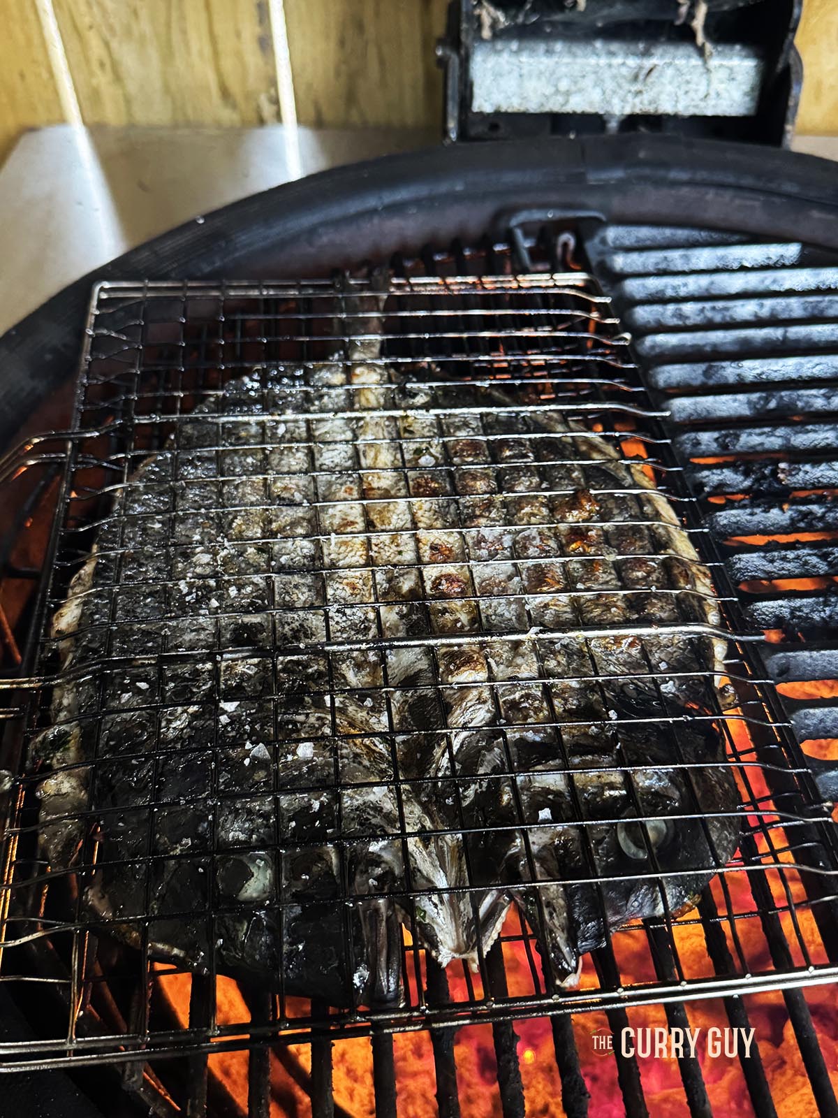 Der Fisch auf dem Grill zeigt die knusprige Haut des Fisches.