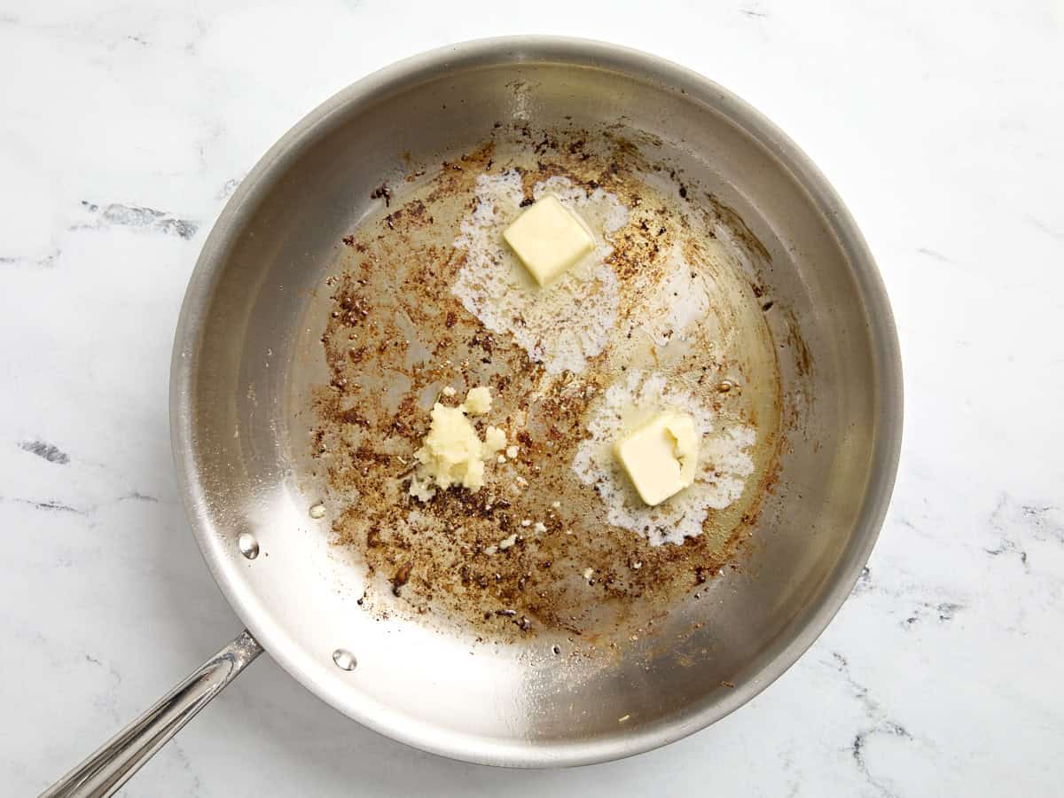 Butter und Knoblauch in eine große Bratpfanne geben.