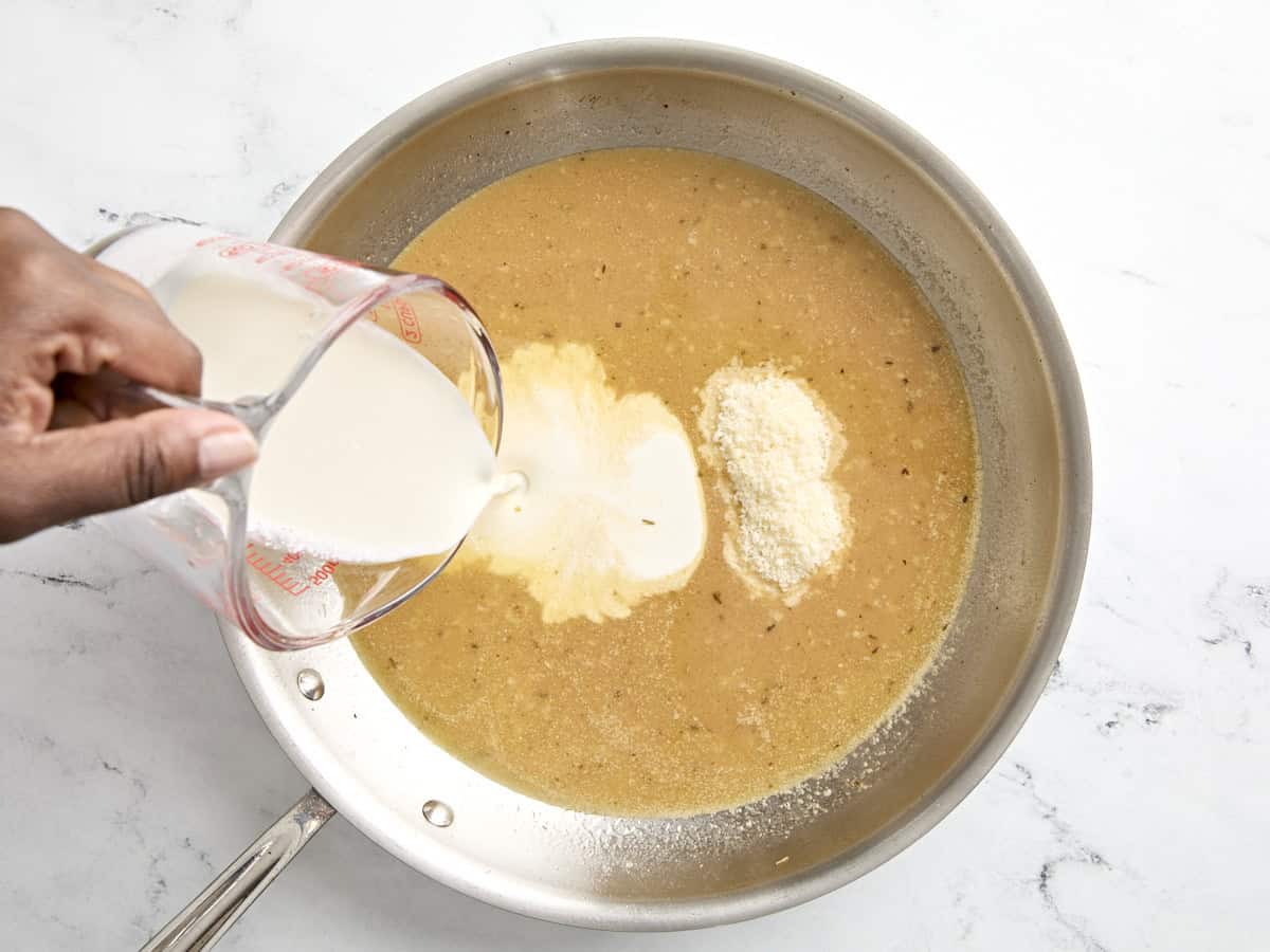 Sahne und Parmesankäse in die Pfanne geben.