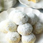 Pyramid stacks of almond and pistachio Italian wedding cookies dusted with powdered sugar. (Russian Tea Cakes)