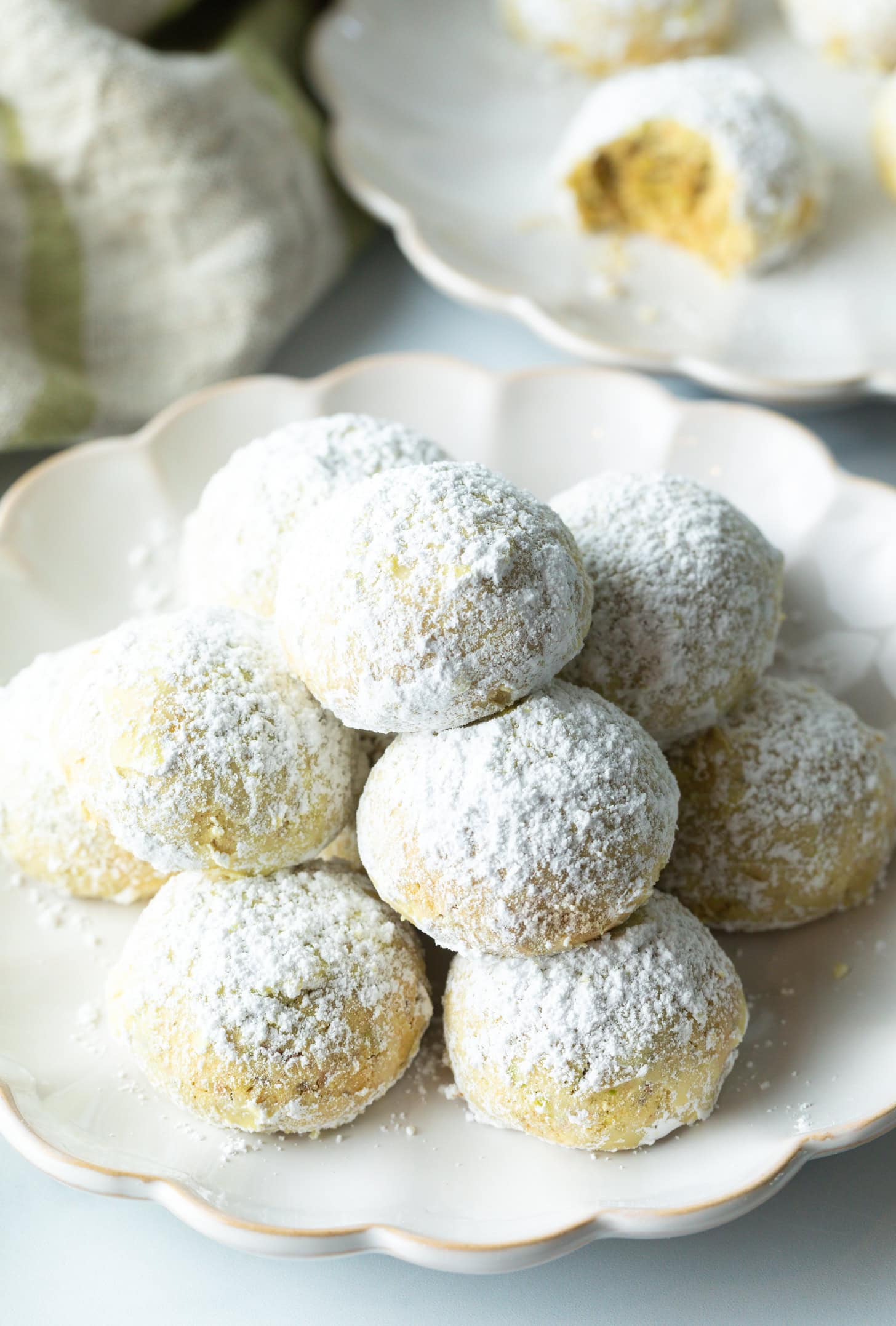 Pyramid stacks of almond and pistachio Italian wedding cookies dusted with powdered sugar. (Russian Tea Cakes)