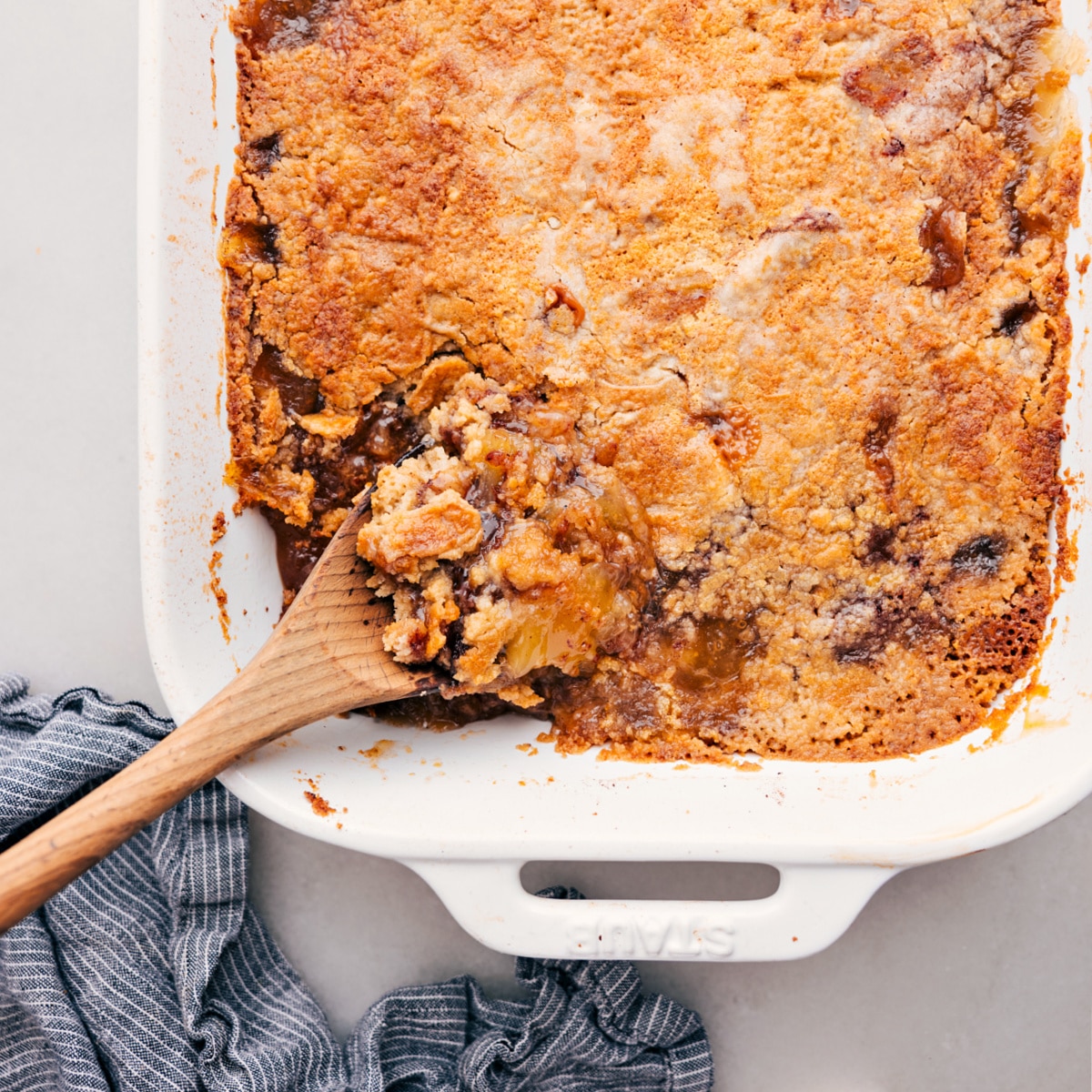 Apfel-Dump-Kuchen in die Auflaufform geben und mit einem Löffel eine Kugel herausnehmen.