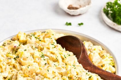 bowl of potato salad with wooden spoon