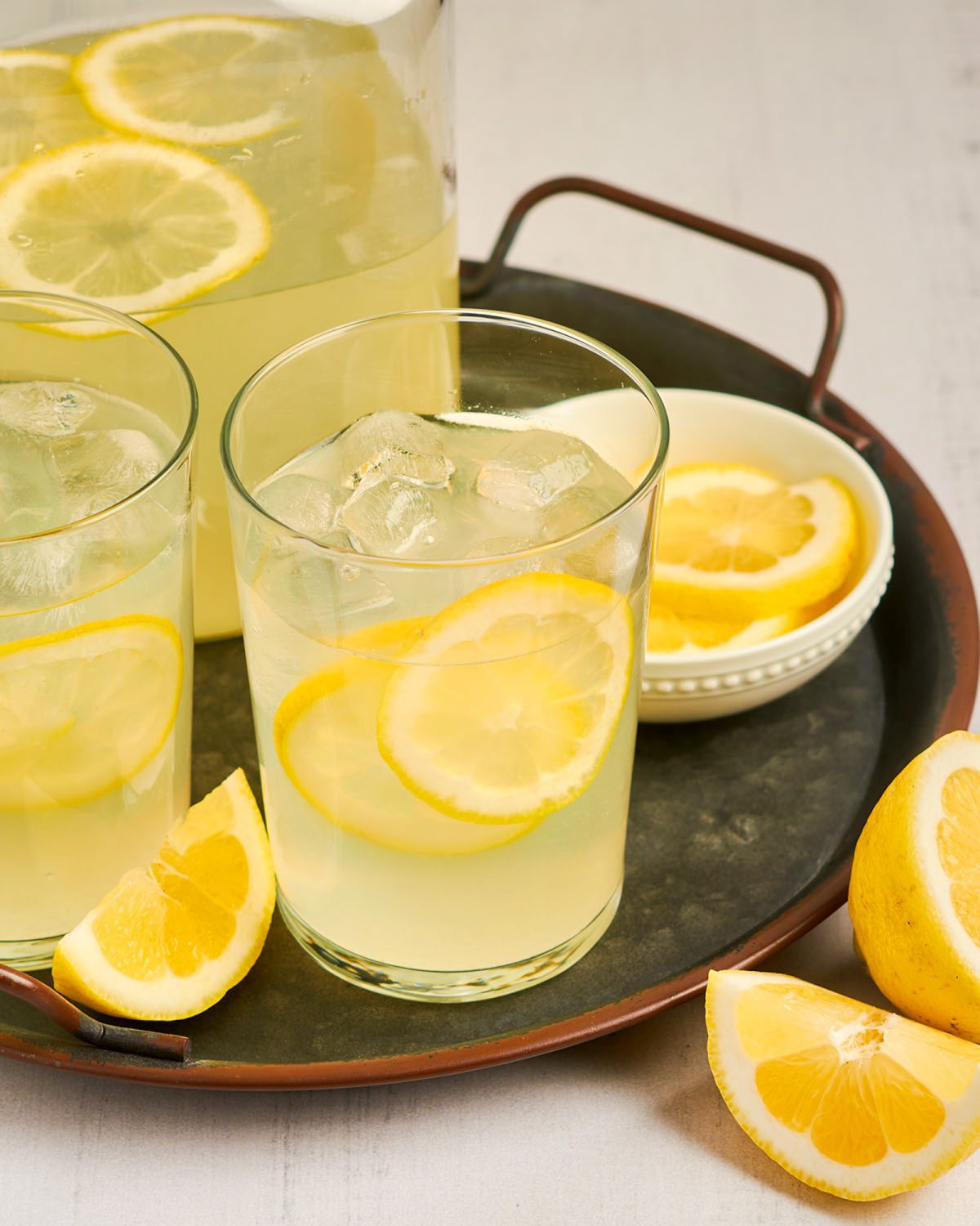 Gläser und Krug mit hausgemachter Limonade auf Tablett