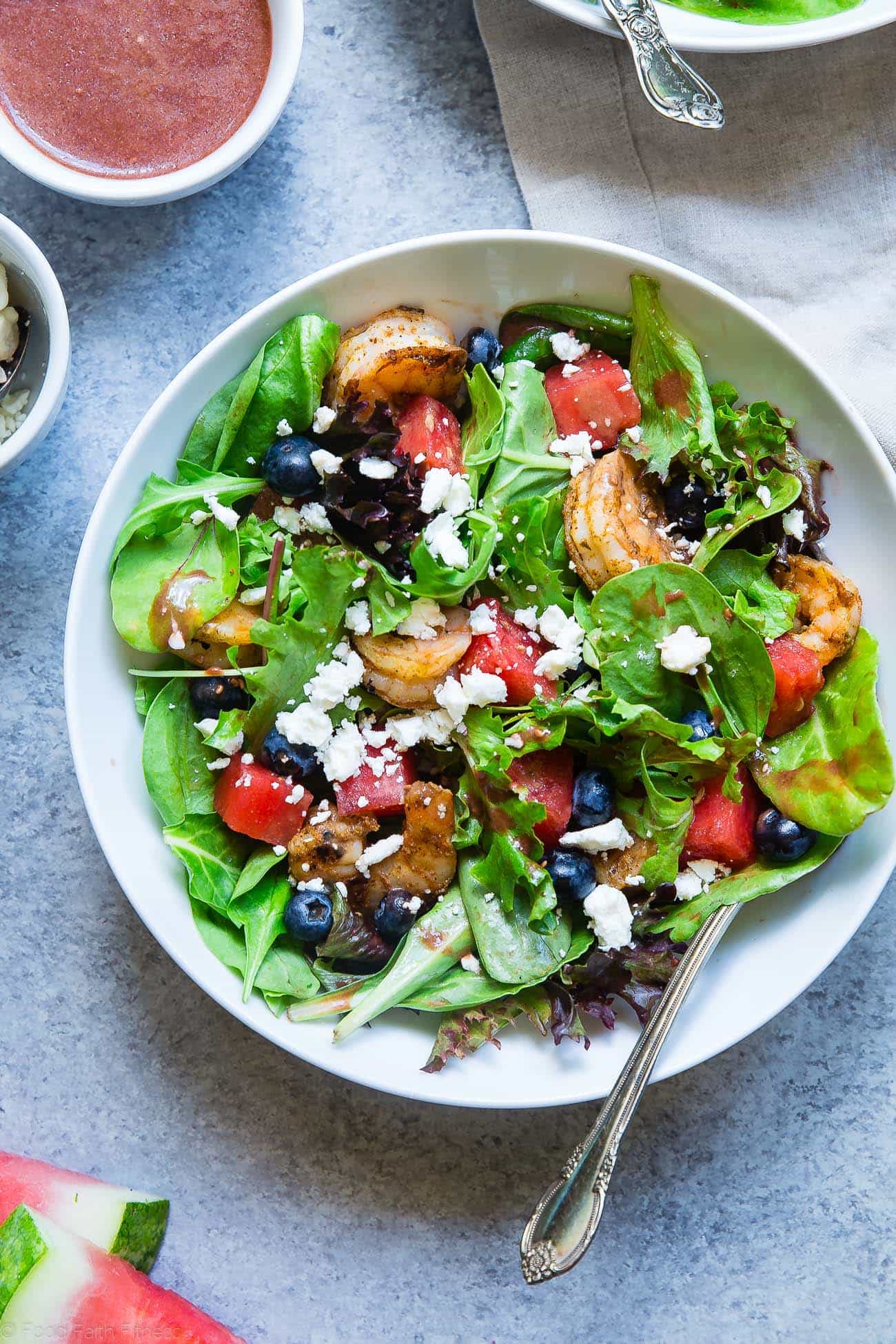 Nahaufnahme eines Wassermelonen-Feta-Salats mit Cajun-Garnelen in einer Schüssel. Rezept auf Foodfaithfitness.com