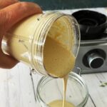 tahini sauce being poured into a jar.