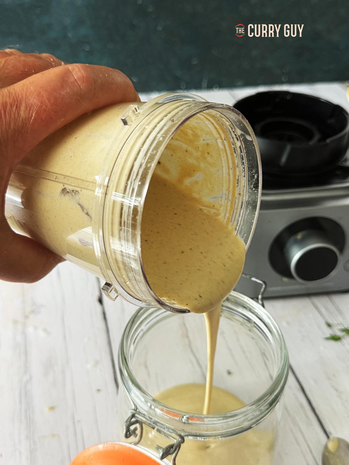 tahini sauce being poured into a jar.