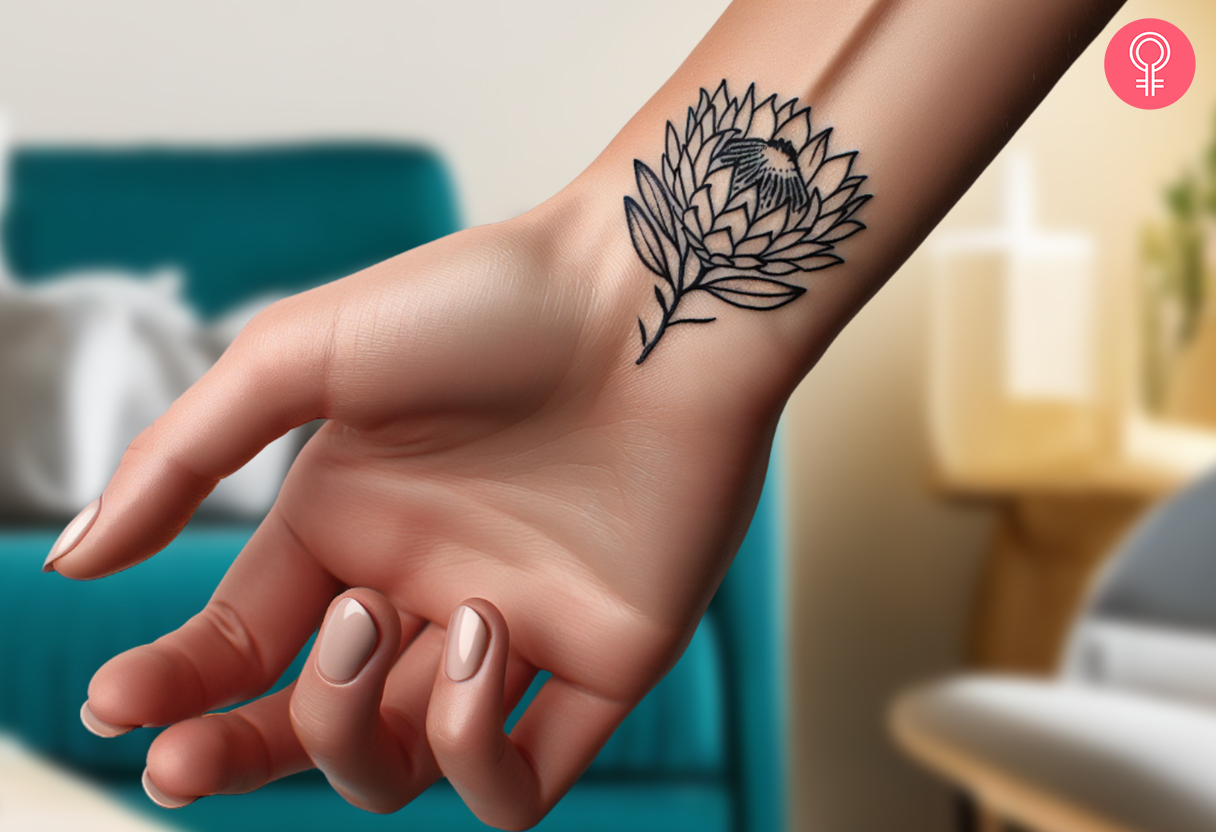 Ein minimalistisches Protea-Tattoo auf der Innenseite des Handgelenks einer Frau