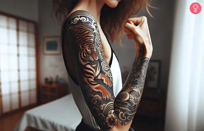 Eine Frau mit einem farbigen chinesischen Tierkreis-Tiger-Tattoo auf dem ganzen Arm