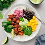 Mojo Salmon Bowls with all the toppings and dressing ready to be enjoyed.