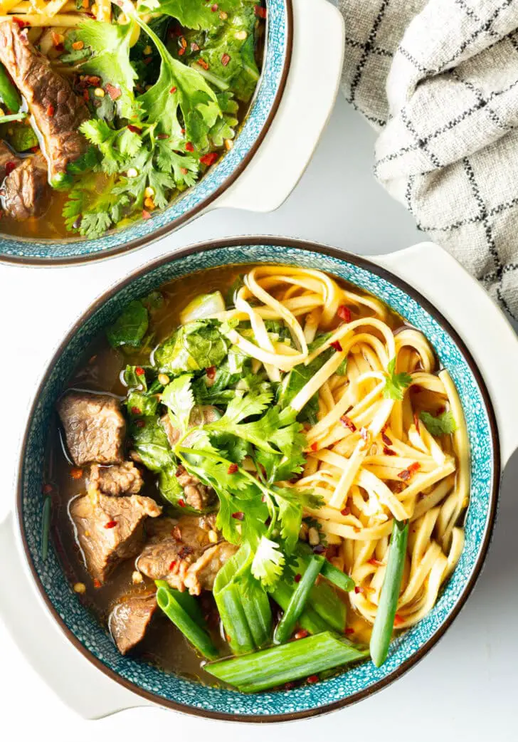 Von oben eine Schüssel taiwanesische Rindfleischsuppe mit Nudeln, grünen Frühlingszwiebeln und gehacktem Pak Choi.