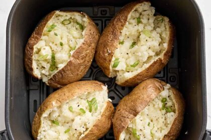 Overhead view of air fryer baked potatoes in an air fryer basket.