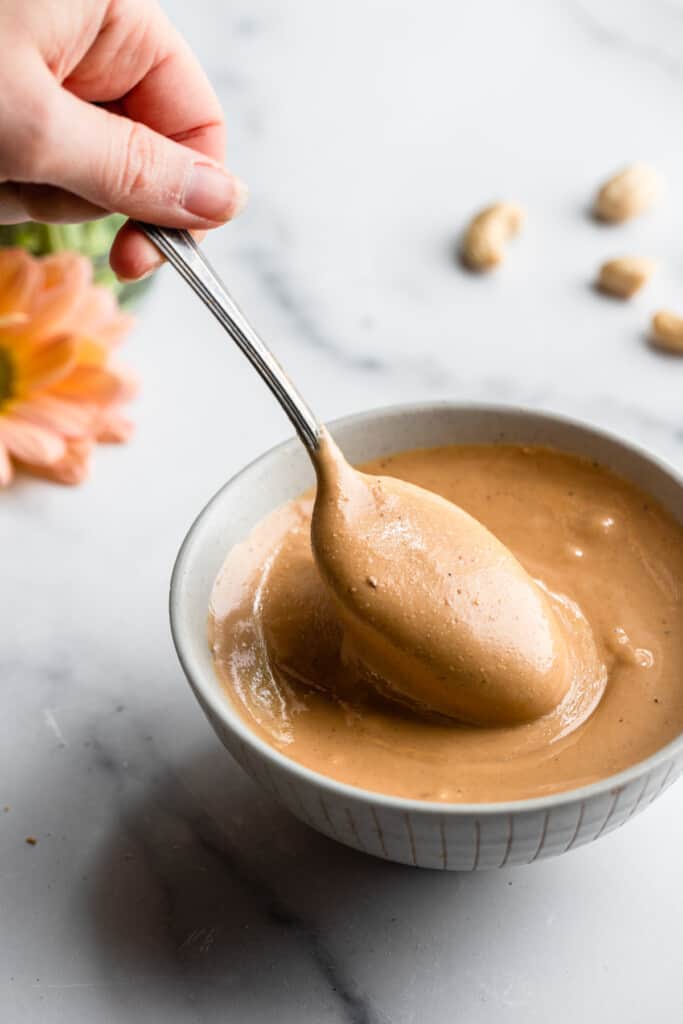 eine Schüssel voll Cashewbutter mit einem Löffel