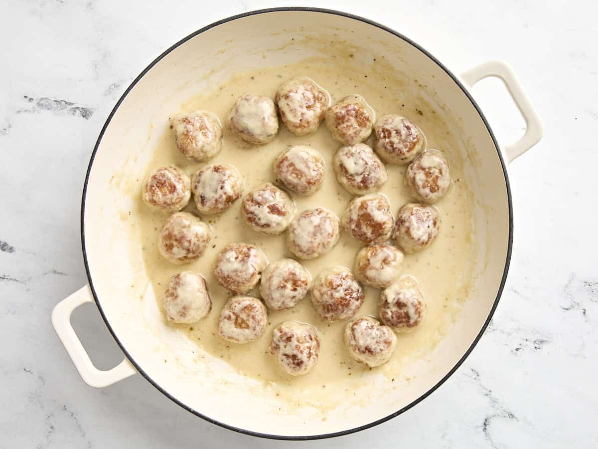 Hühnerfleischbällchen in Sahnesauce zurück in die Pfanne gegeben.