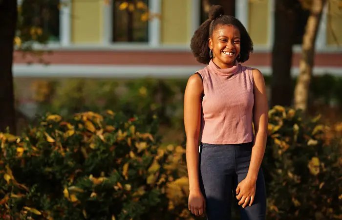 Eine Frau mit Afro-Haar trägt eine schnell geflochtene, halb hochgesteckte, halb offene Frisur