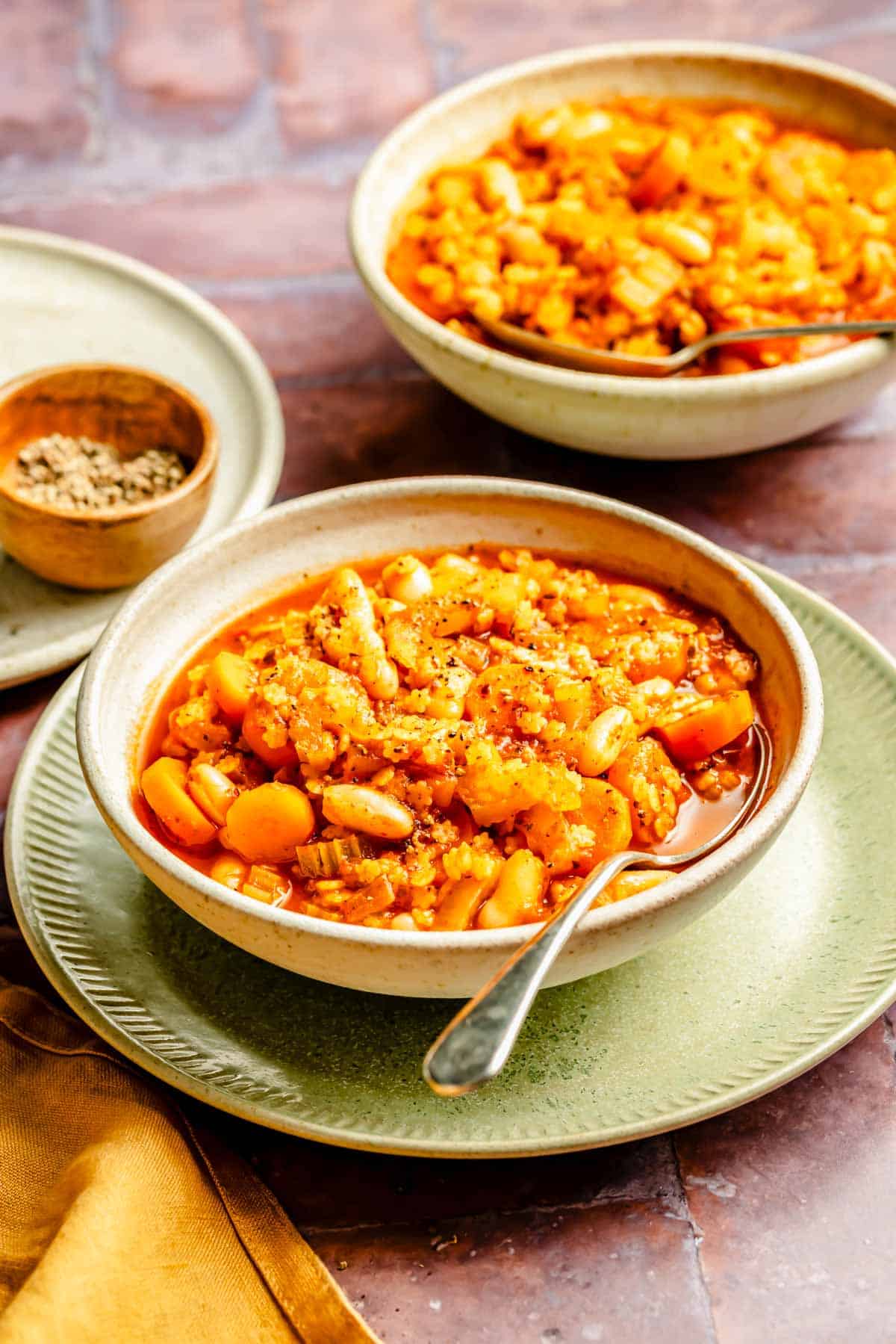 ein Metalllöffel ruht in einer Schüssel Minestrone Löffel auf einem grünen Teller