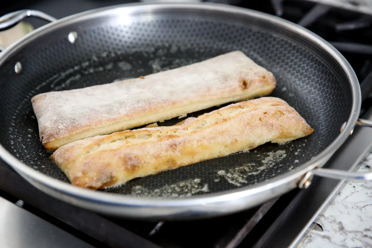 ein Brötchen in einer Pfanne toasten