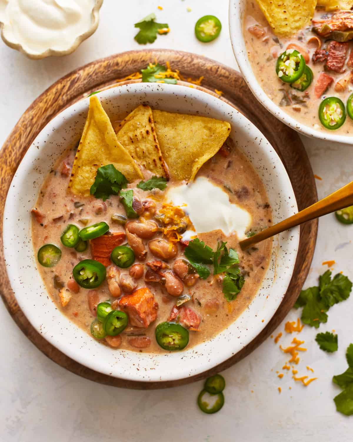 Zwei Schüsseln Chili mit Tortillachips und Sauerrahm.