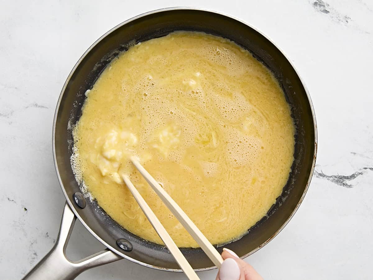 Rührei-Mischung in eine Pfanne geben und mit Stäbchen verquirlen.