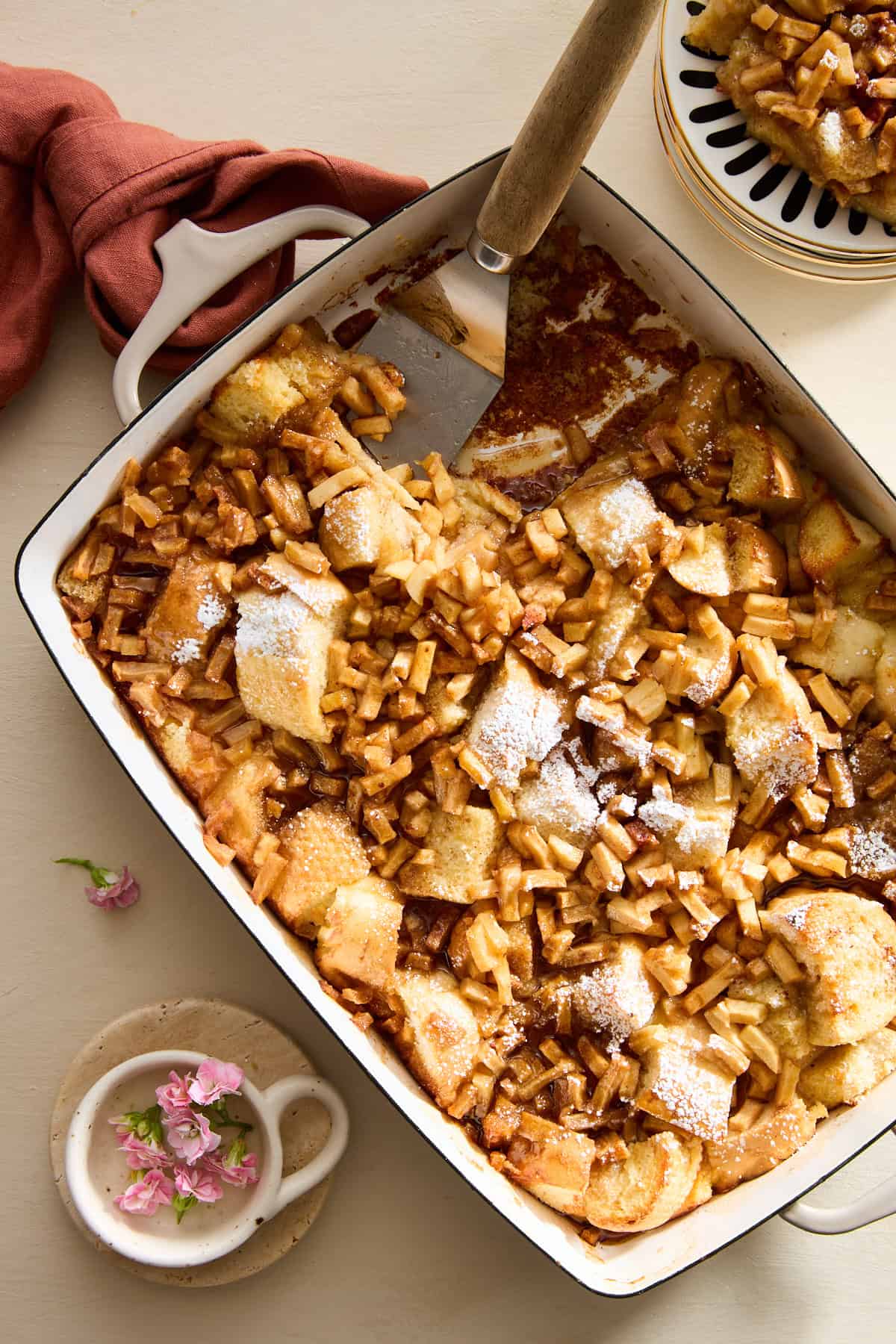 Eine Servierplatte mit French Toast mit Apfel und Zimt und einem Spatel anstelle einer fehlenden Portion. 