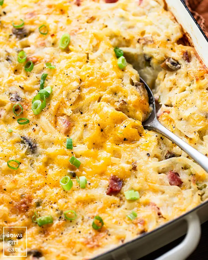 Servierlöffel in Käse-Schinken und Hash Brown Auflauf