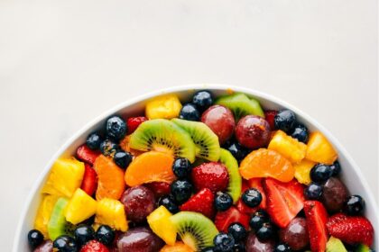 The easy fruit salad recipe in a bowl with serving spoons.