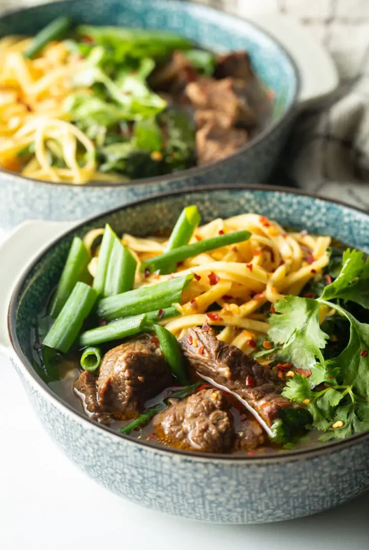 Schüssel taiwanesische Rindfleischsuppe mit Nudeln, grünen Frühlingszwiebeln und gehacktem Pak Choy.