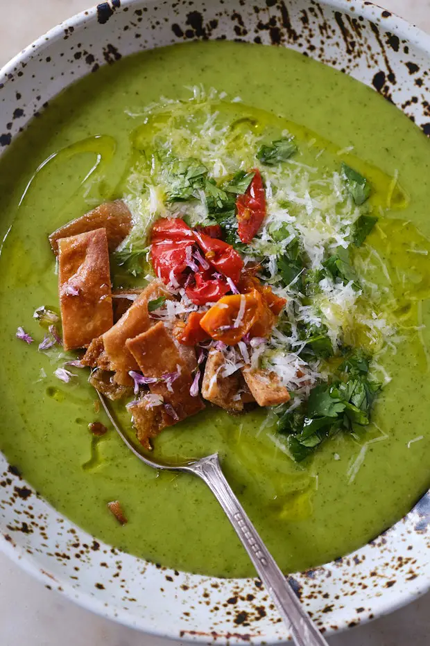 Zucchinisuppe in einer Schüssel mit Löffel und Toppings