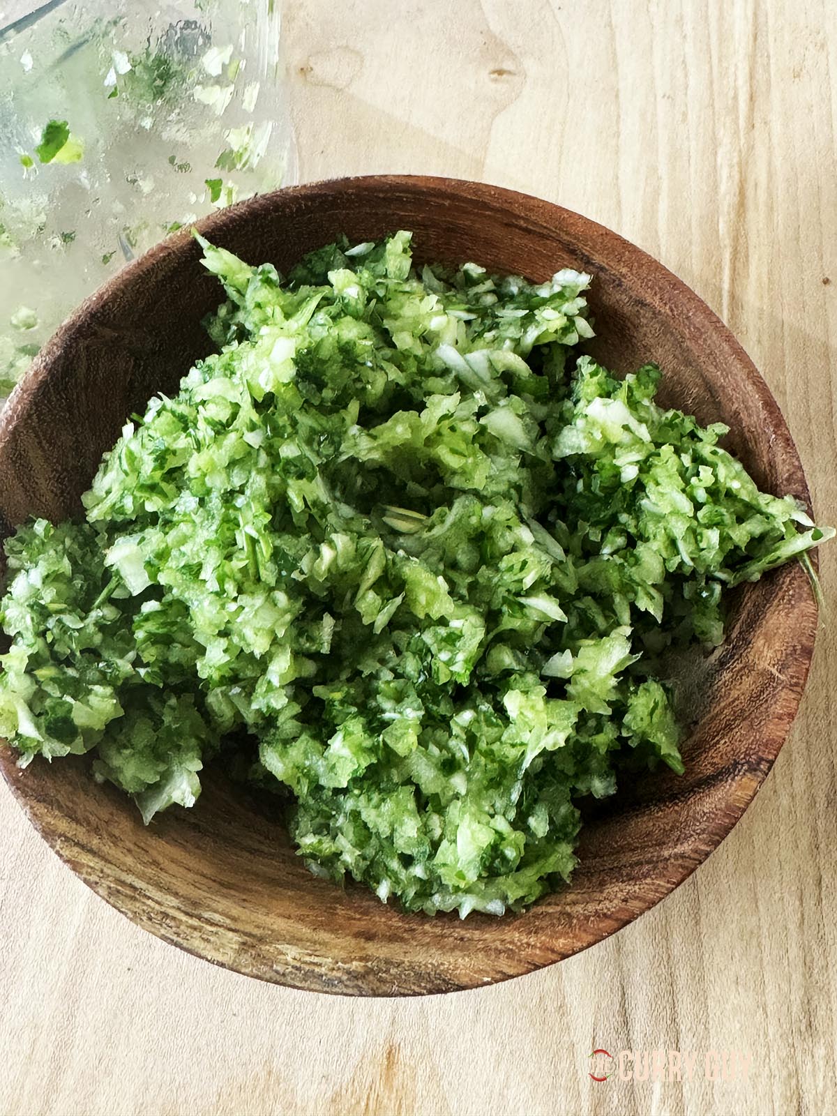 Petersilie, Knoblauch und Zwiebel in einer Schüssel grob hacken.