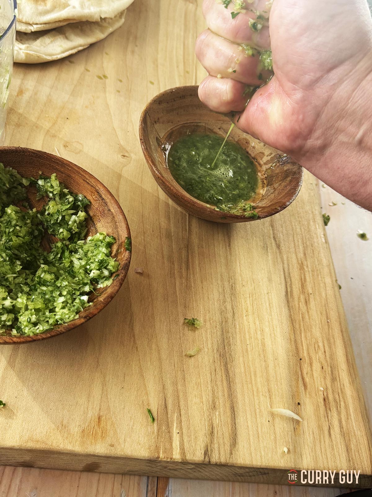 Die überschüssige Flüssigkeit aus der Zwiebel-Knoblauch-Petersilien-Mischung auspressen.