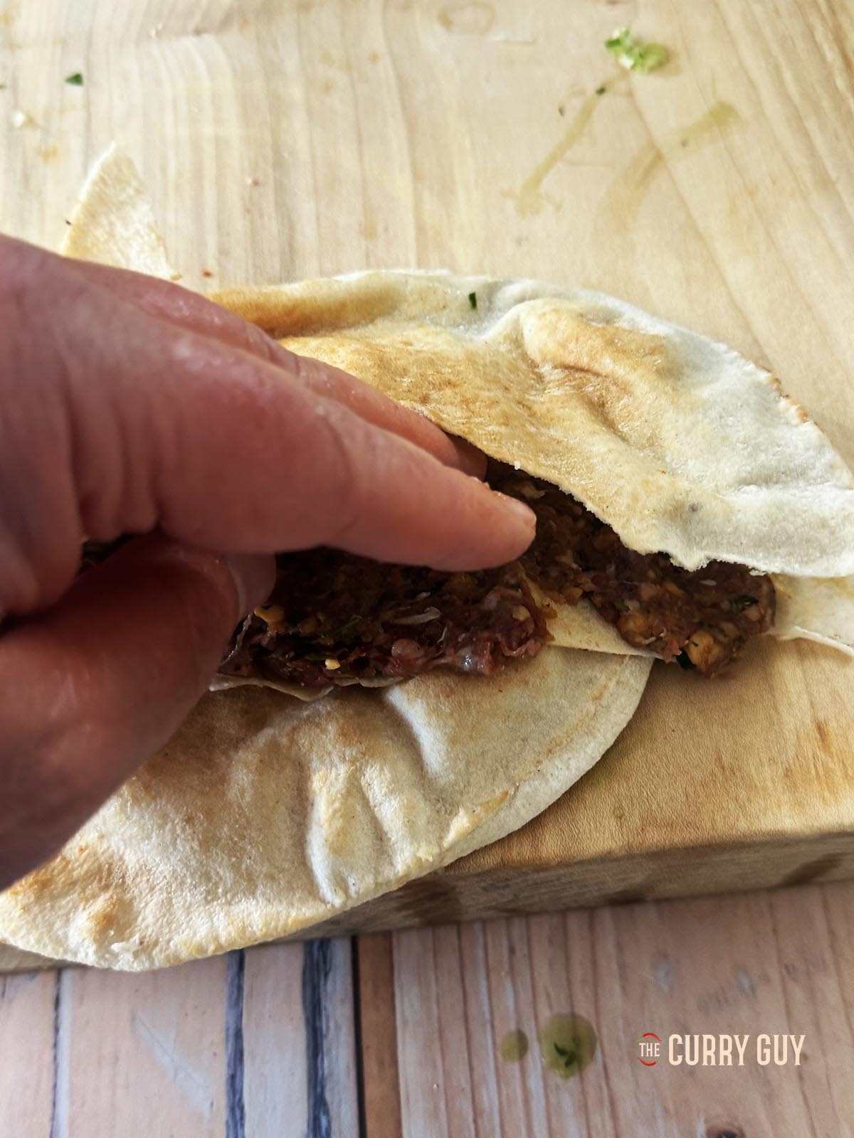 Drücken Sie das Fleisch über die untere Schicht des Pita.