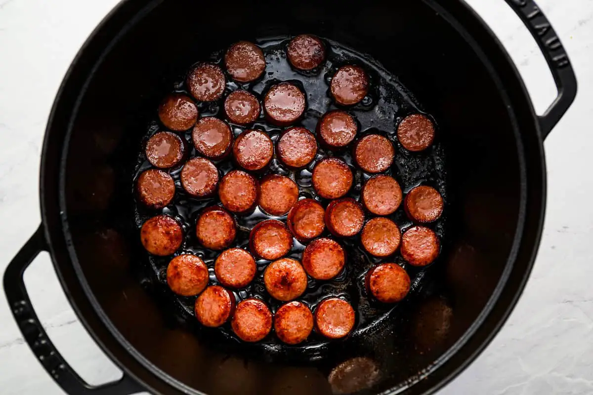 Kielbasa-Scheiben, die in einem holländischen Ofen gekocht werden.